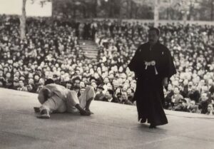 Hideichi Nagaoka (1876-1952): Maestro di judo e arbitro durante una competizione, dimostrando la sua dedizione e competenza nelle arti marziali.